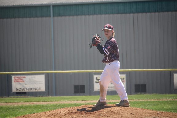 A baseball player on the pitcher's mound prepares to throw a pitch.